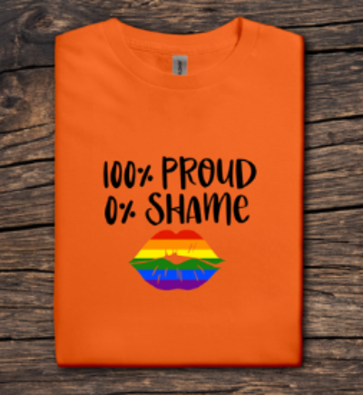 Orange t-shirt with '100% Proud 0% Shame' text and rainbow lips design on a wooden surface