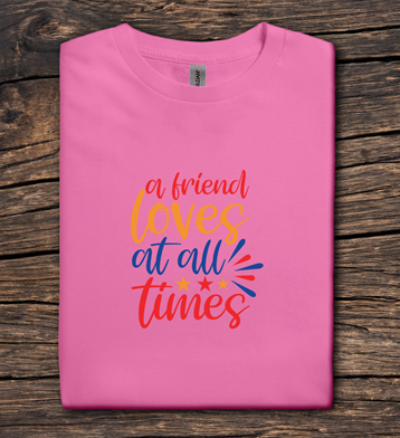 Pink t-shirt with colorful text on a wooden surface
