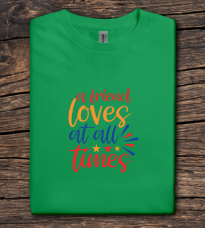Green t-shirt with colorful text on a wooden surface