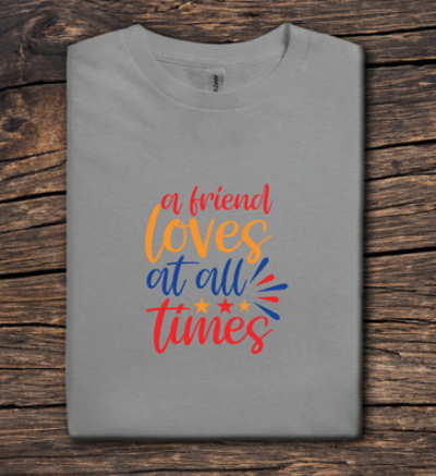 Folded gray t-shirt with colorful text on a wooden surface
