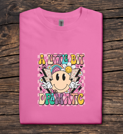 Pink t-shirt with colorful graphic design on a wooden surface