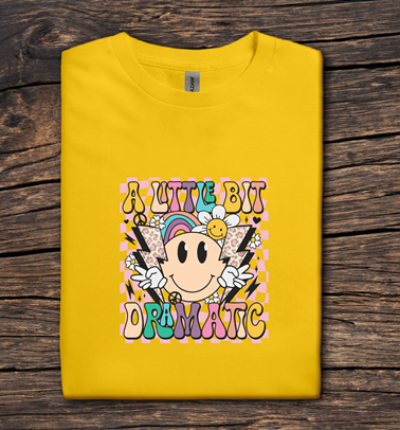 Yellow t-shirt with colorful graphic design on a wooden surface