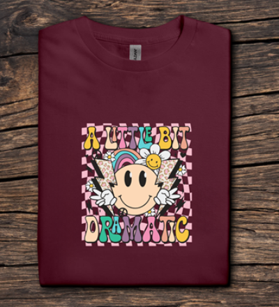 Maroon t-shirt with colorful graphic design on a wooden surface