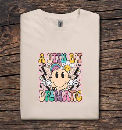 Beige t-shirt with colorful graphic design on a wooden surface