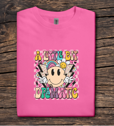 Pink t-shirt with colorful graphic design on a wooden surface