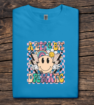 Blue t-shirt with colorful graphic design on a wooden surface