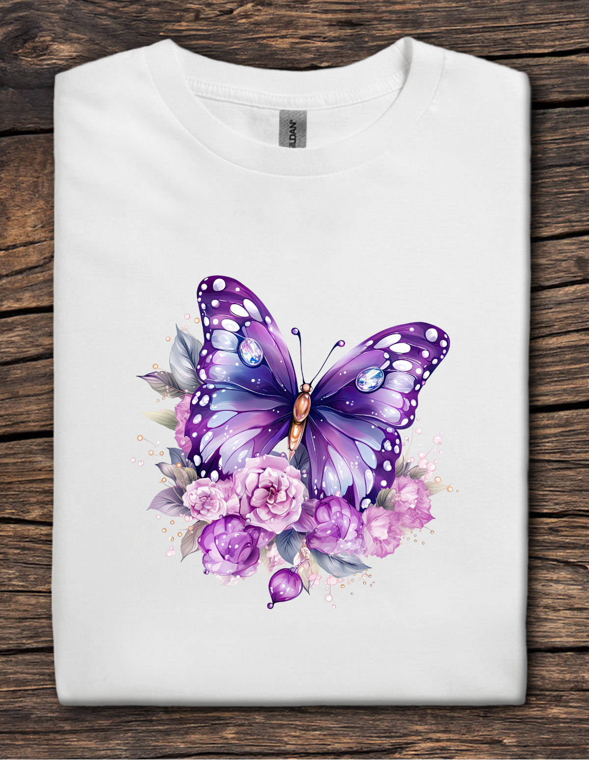 White t-shirt with a purple butterfly and floral design on a wooden surface