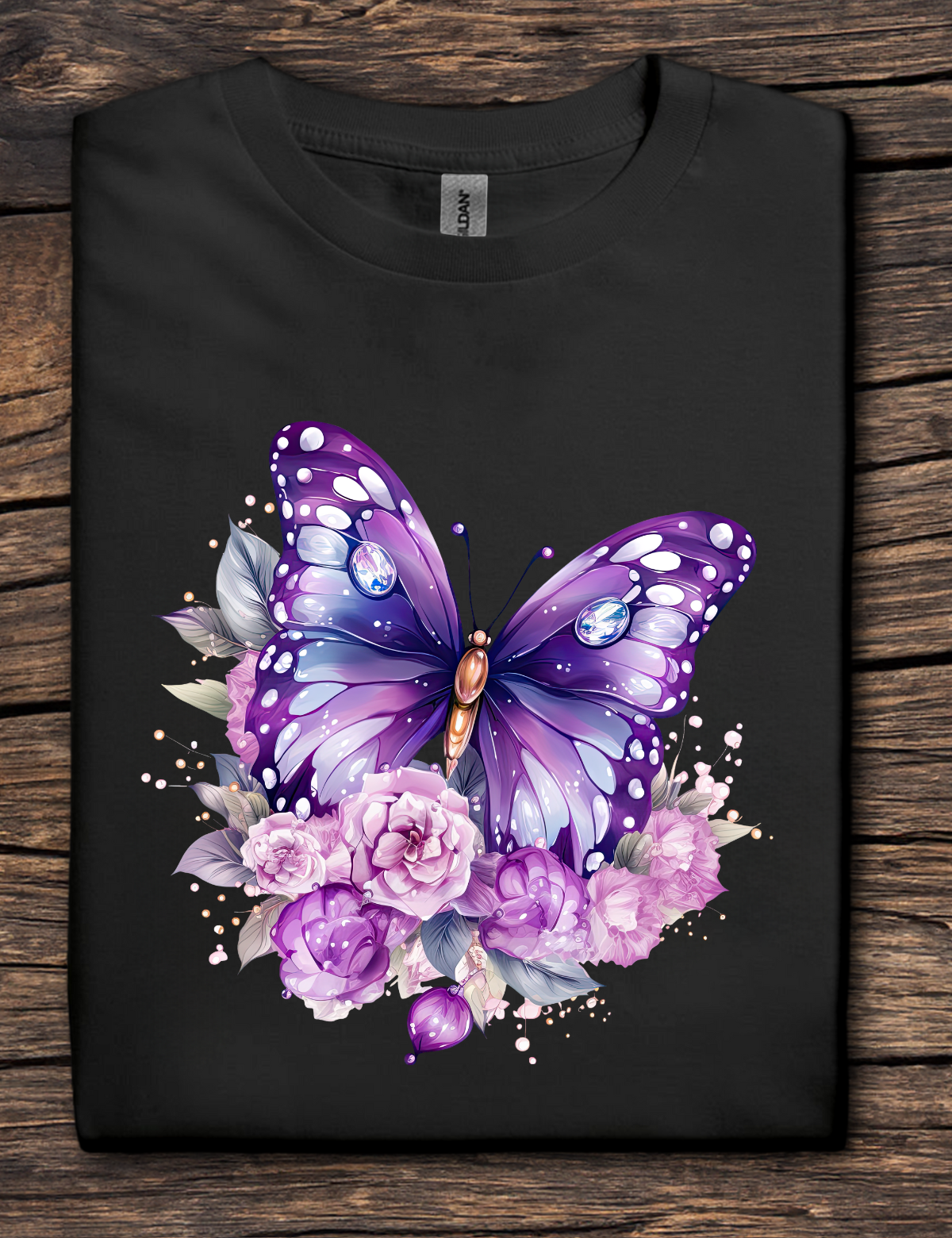 Black t-shirt with a purple butterfly and floral design on a wooden surface