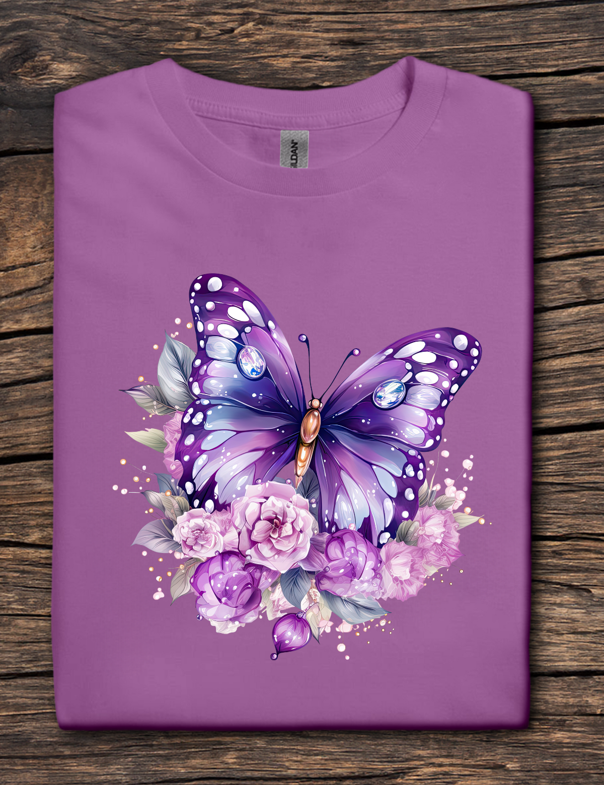 Purple t-shirt with a butterfly and floral design on a wooden surface
