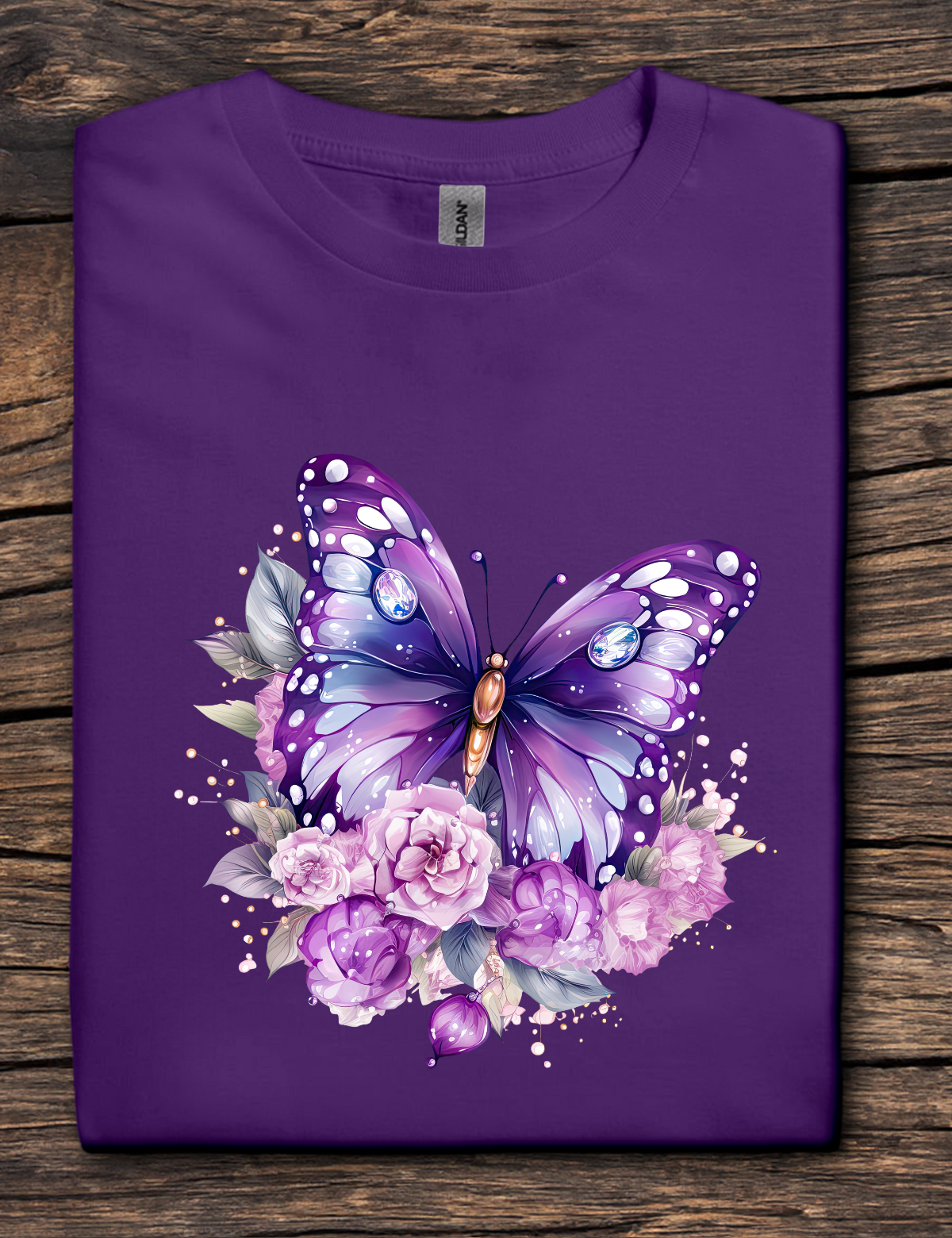 Purple t-shirt with a butterfly and floral design on a wooden surface