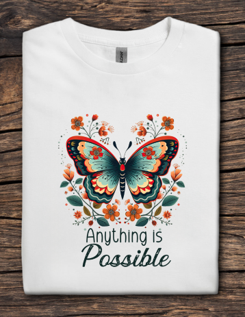 White inspirational t-shirt featuring a colorful butterfly with floral accents and the phrase “Anything Is Possible.”