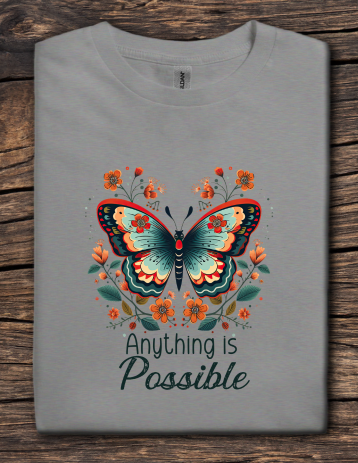 Gray t-shirt with a butterfly design and 'Anything is Possible' text on a wooden surface