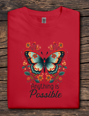 Red t-shirt with a butterfly design and 'Anything is Possible' text on a wooden surface