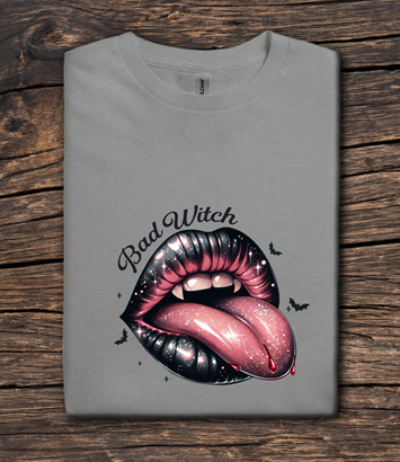 Gray t-shirt with a graphic of lips and 'Bad Witch' text on a wooden surface