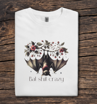 White t-shirt with a bat and floral design on a wooden surface
