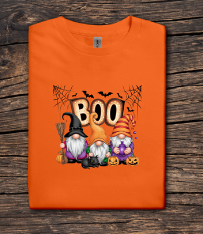 Orange t-shirt with Halloween-themed design featuring gnomes and 'BOO' text on a wooden surface.