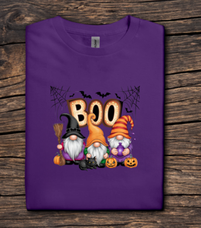 Purple t-shirt with Halloween-themed gnomes and 'BOO' text on a wooden surface