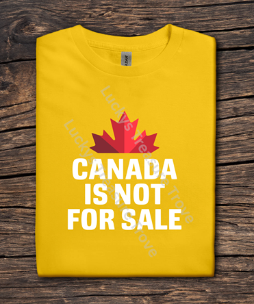 Yellow t-shirt with a red maple leaf and 'Canada is not for sale' text on a wooden surface