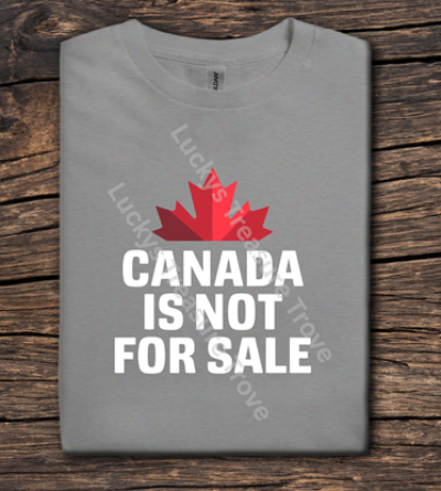 Gray t-shirt with red maple leaf and 'Canada is not for sale' text on a wooden surface