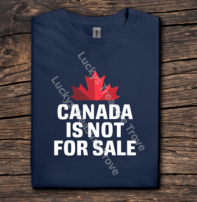 Navy blue t-shirt with red maple leaf and white text 'Canada is not for sale' on a wooden surface.