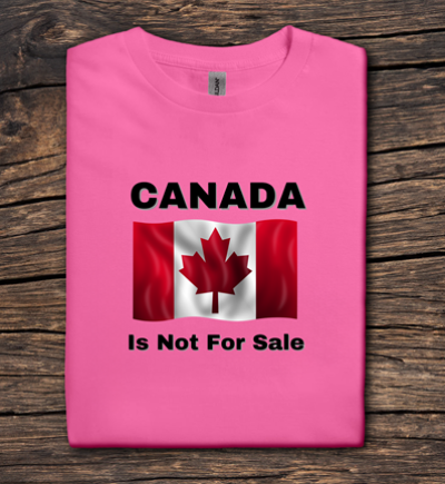 Pink t-shirt with Canadian flag and 'Canada is Not For Sale' text on a wooden surface