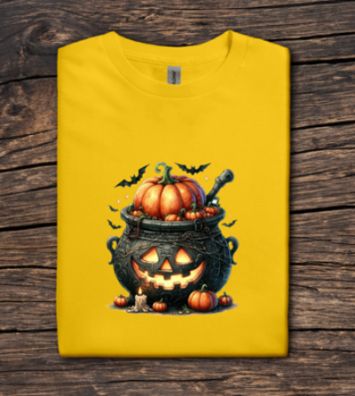 Yellow t-shirt with Halloween-themed design featuring pumpkins and a cauldron on a wooden surface.