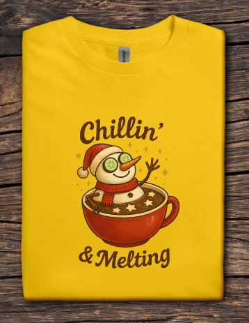 Yellow t-shirt featuring a snowman relaxing in a mug of hot cocoa with the text “Chillin’ & Melting”.