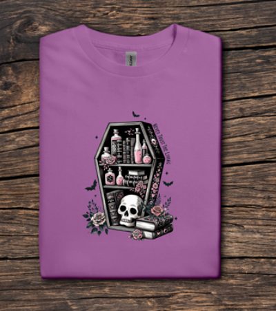 Purple t-shirt with a coffin design featuring骷髅和物品 on a wooden surface