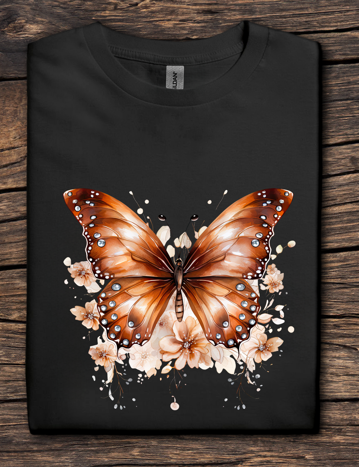 Black t-shirt with a brown butterfly design on a wooden surface