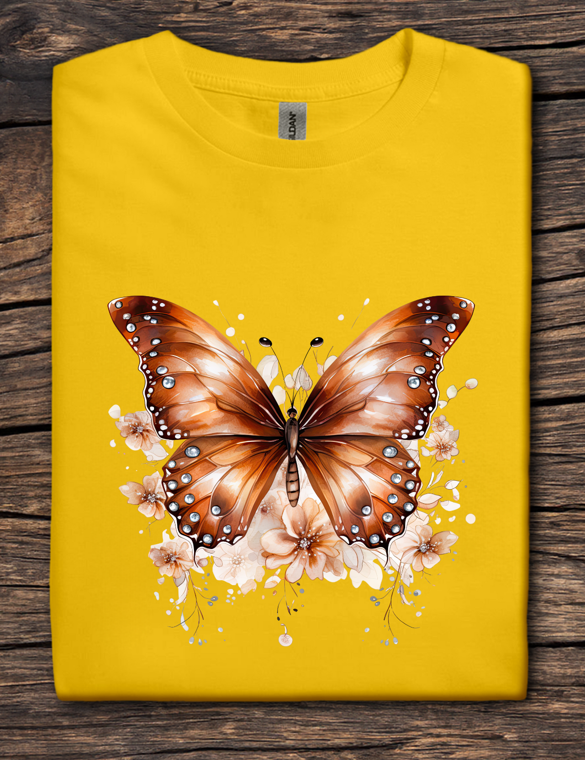 Yellow t-shirt with copper-colored butterfly graphic surrounded by soft floral accents.