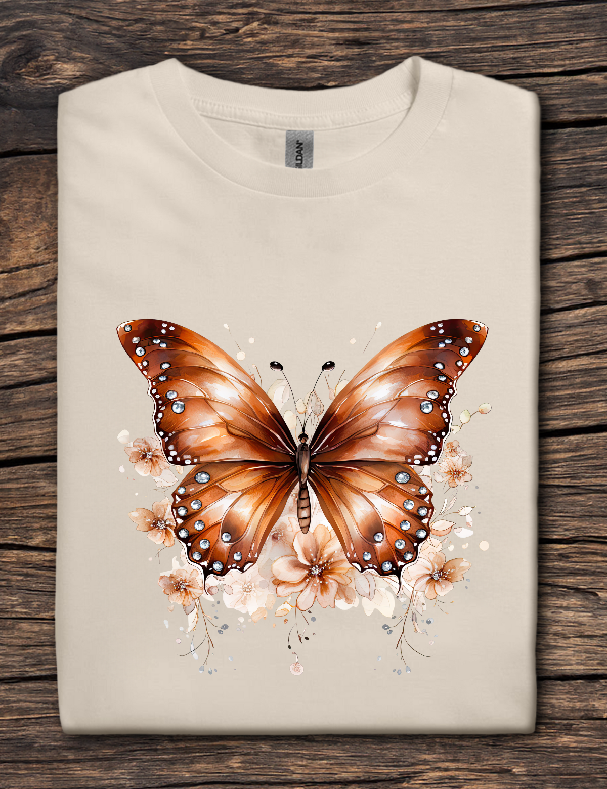 Beige t-shirt with a brown butterfly design on a wooden surface