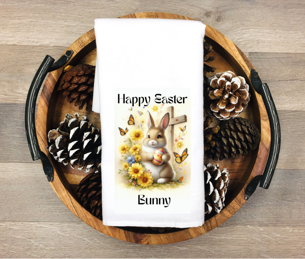 Easter-themed towel with bunny and flowers on a wooden tray with pinecones