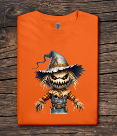 Orange t-shirt with a scarecrow graphic on a wooden surface