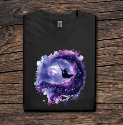 Black t-shirt with a colorful design of a silhouette against a cosmic background on a wooden surface.