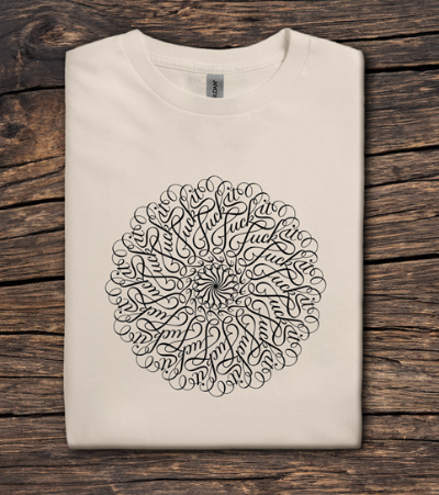 Folded beige t-shirt with black circular design on a wooden surface