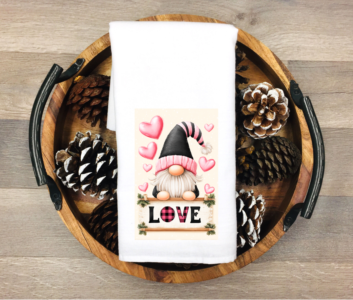 Decorative towel with a gnome and 'LOVE' text on a wooden tray with pinecones