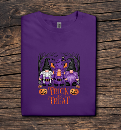 Purple t-shirt with Halloween design featuring gnomes and pumpkins on a wooden surface