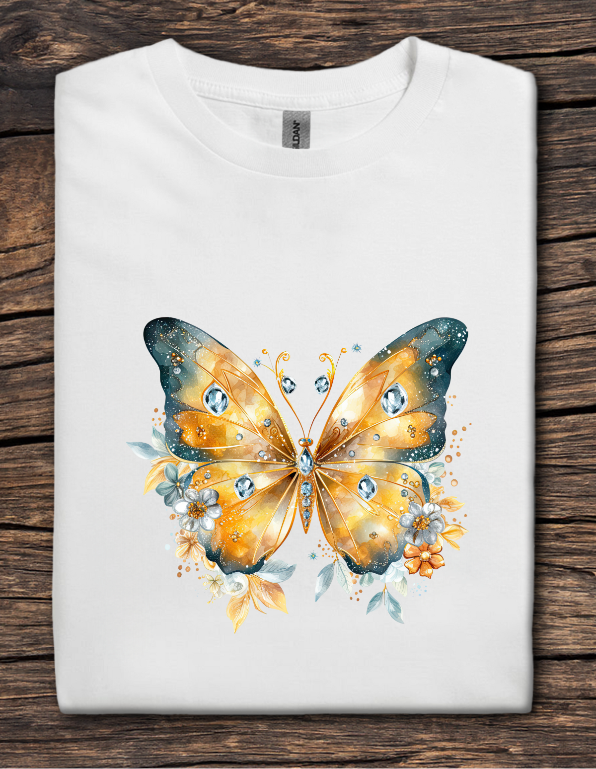 White t-shirt featuring a golden jeweled butterfly with floral accents and soft teal details.