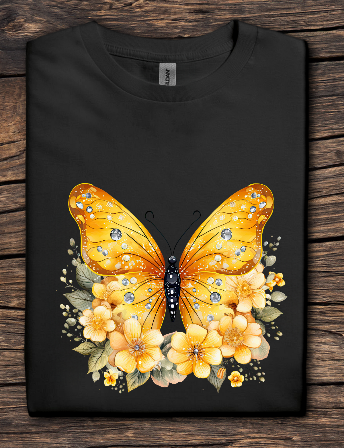 Black t-shirt with a yellow butterfly and floral design on a wooden surface