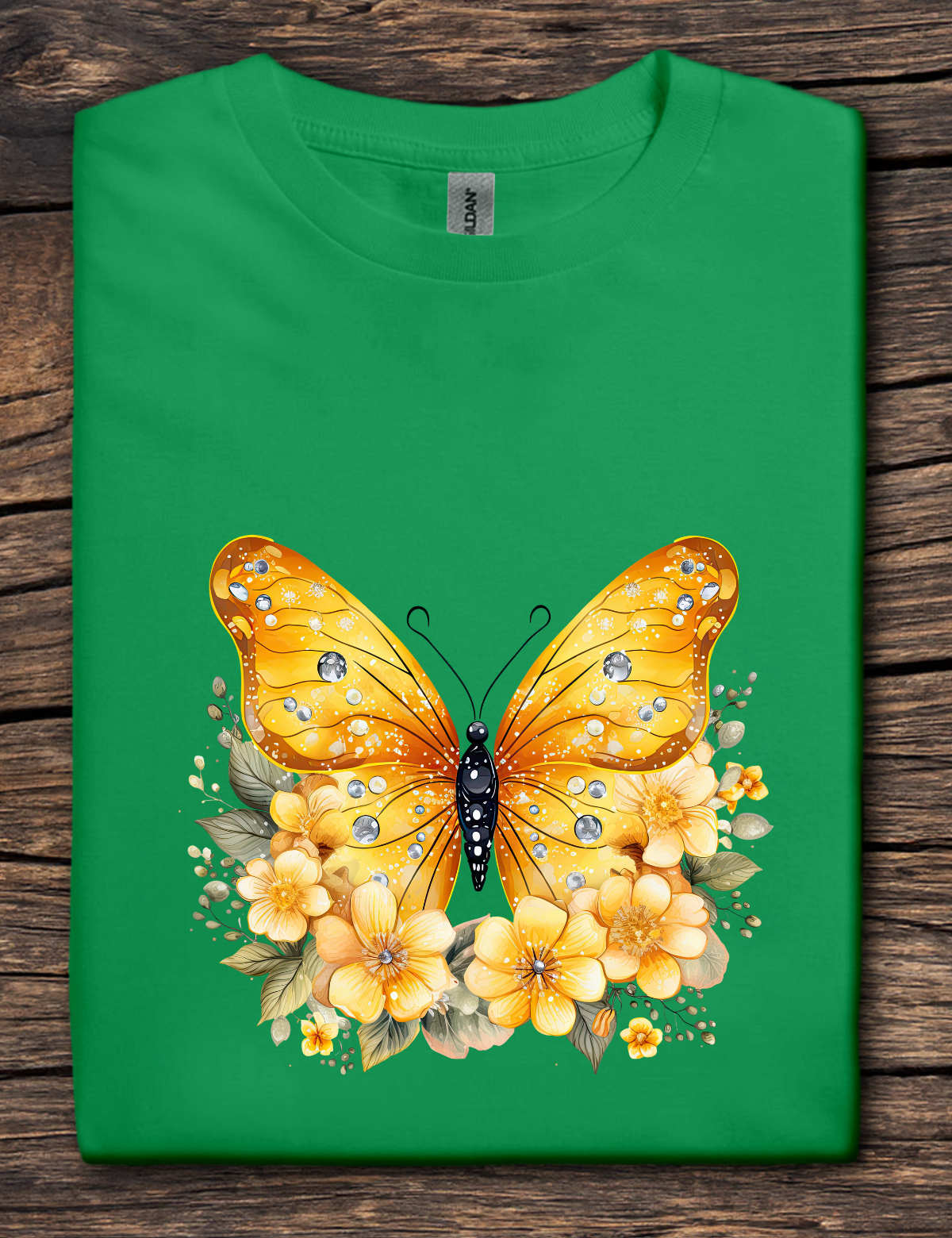 Green t-shirt with a yellow butterfly and flowers design on a wooden surface