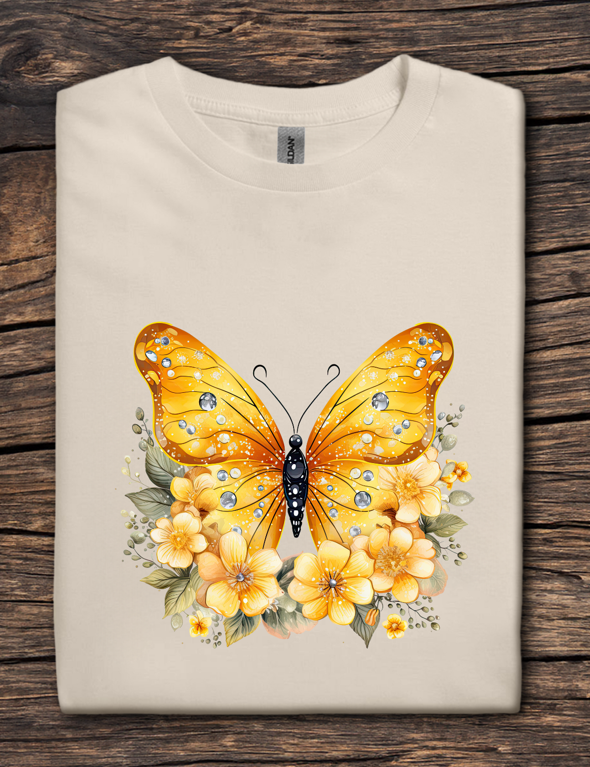 Beige t-shirt with a yellow butterfly and flowers design on a wooden surface
