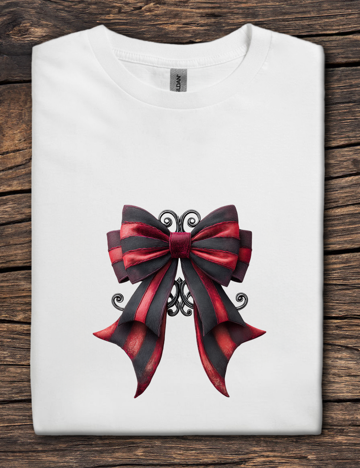 White t-shirt with a large red and black bow design on a wooden surface