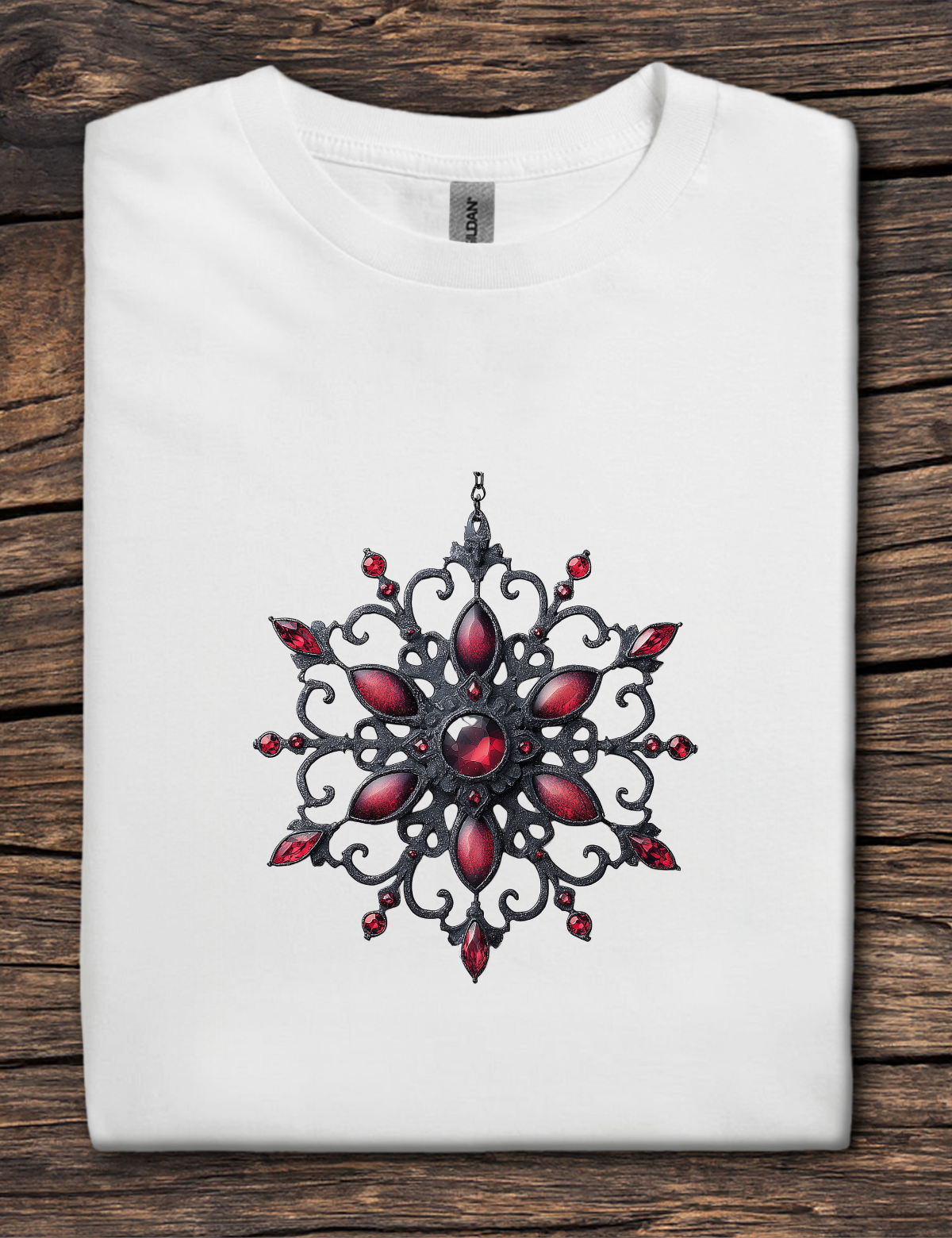 White t-shirt with a red and black decorative design on a wooden surface