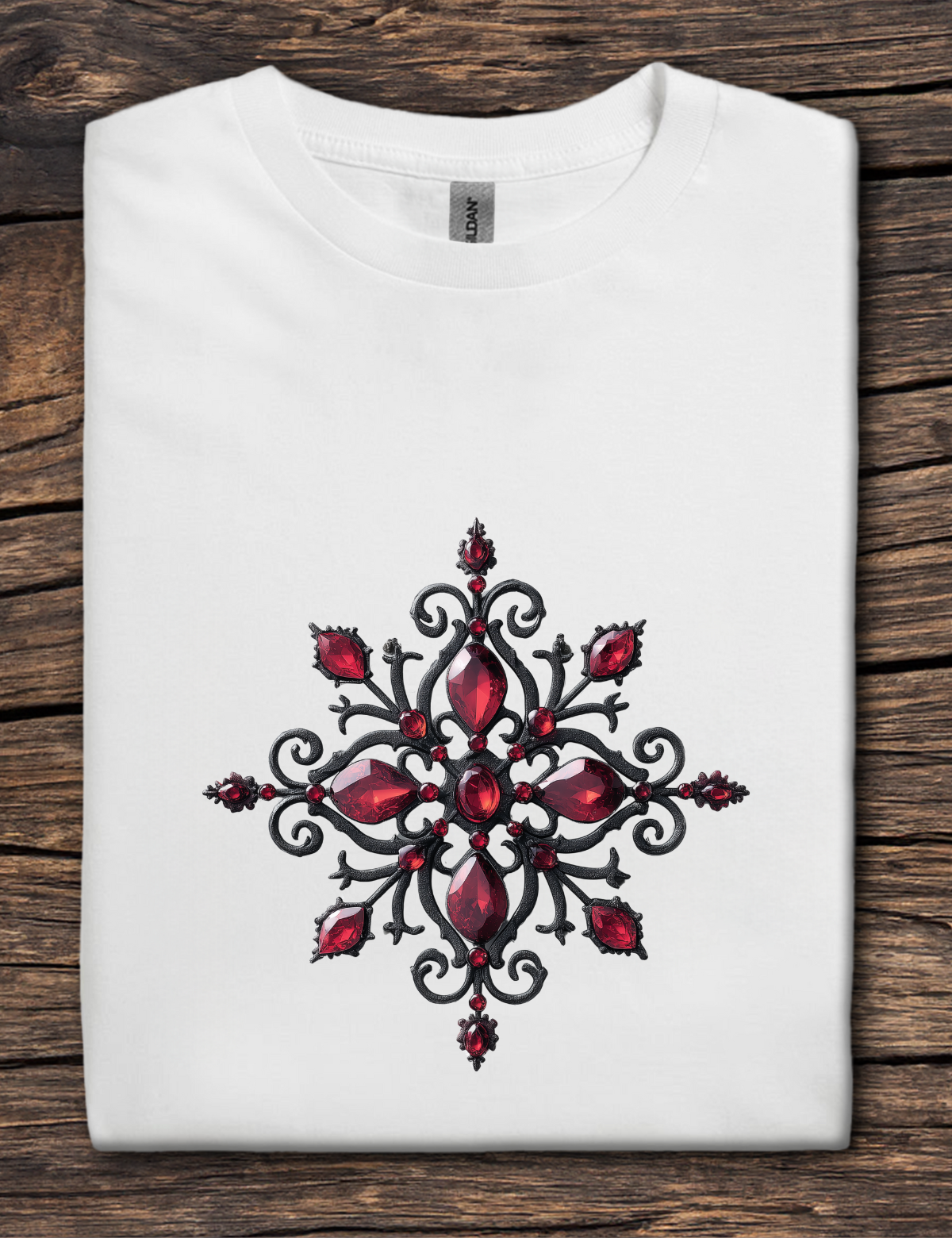 White t-shirt with a red and black decorative design on a wooden surface