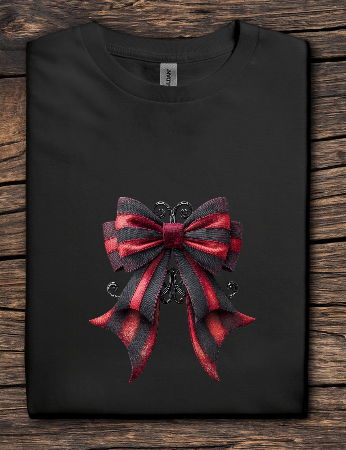 Black t-shirt with a large red and black bow design on a wooden surface