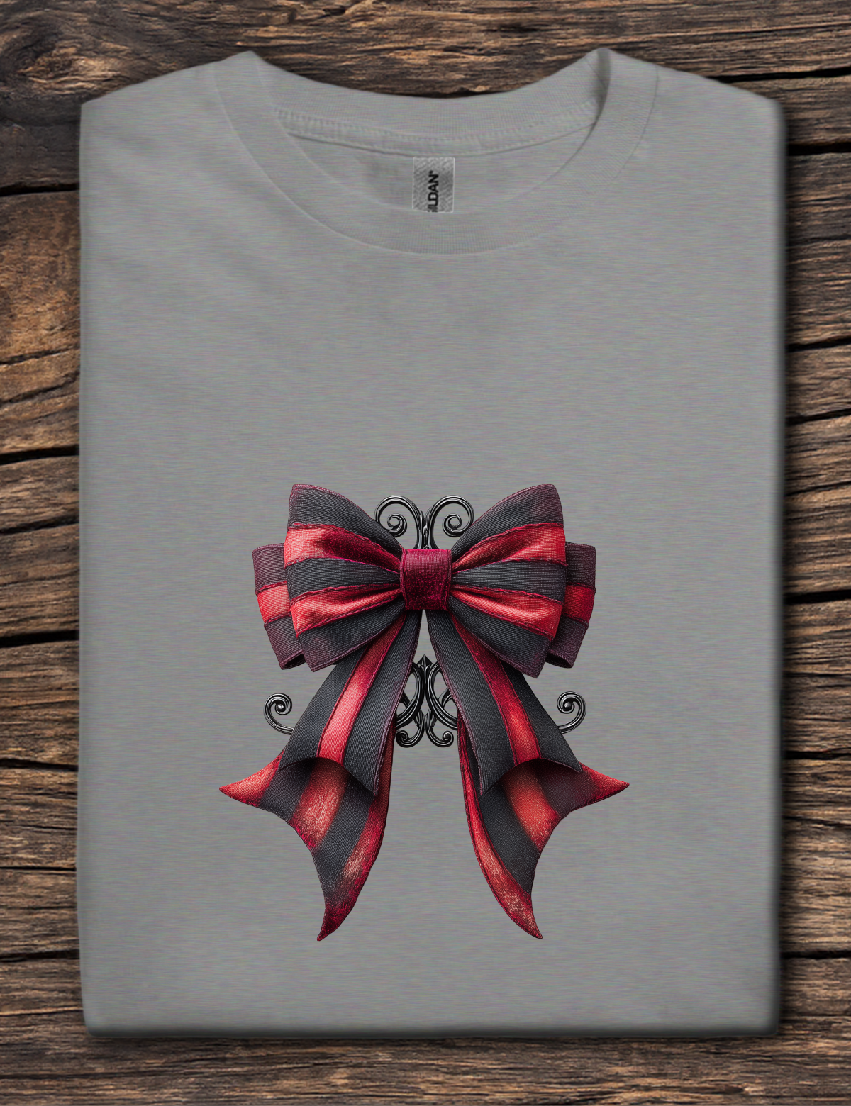 Gray t-shirt with a red and black bow design on a wooden surface