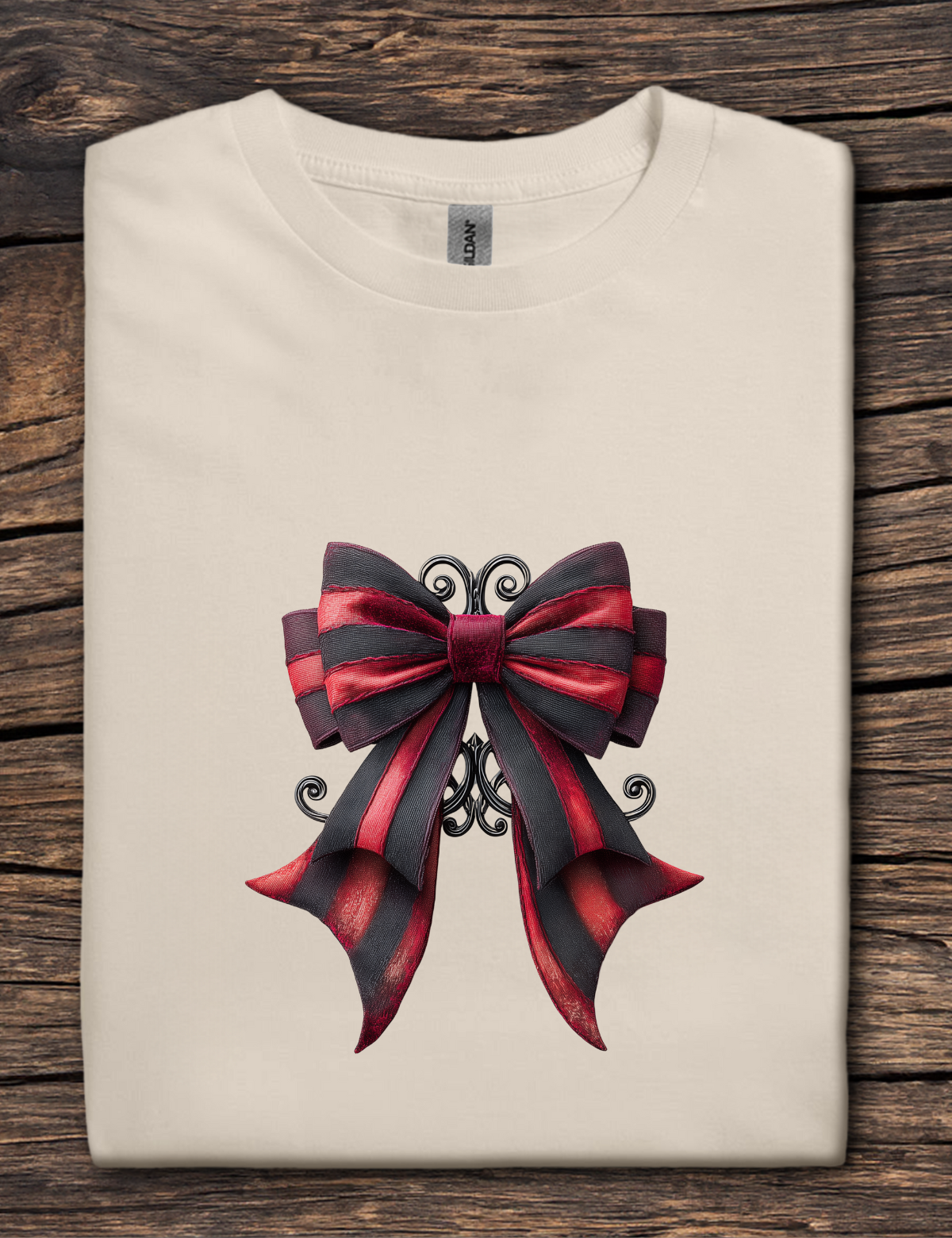 Beige t-shirt with a large red and black bow design on a wooden surface