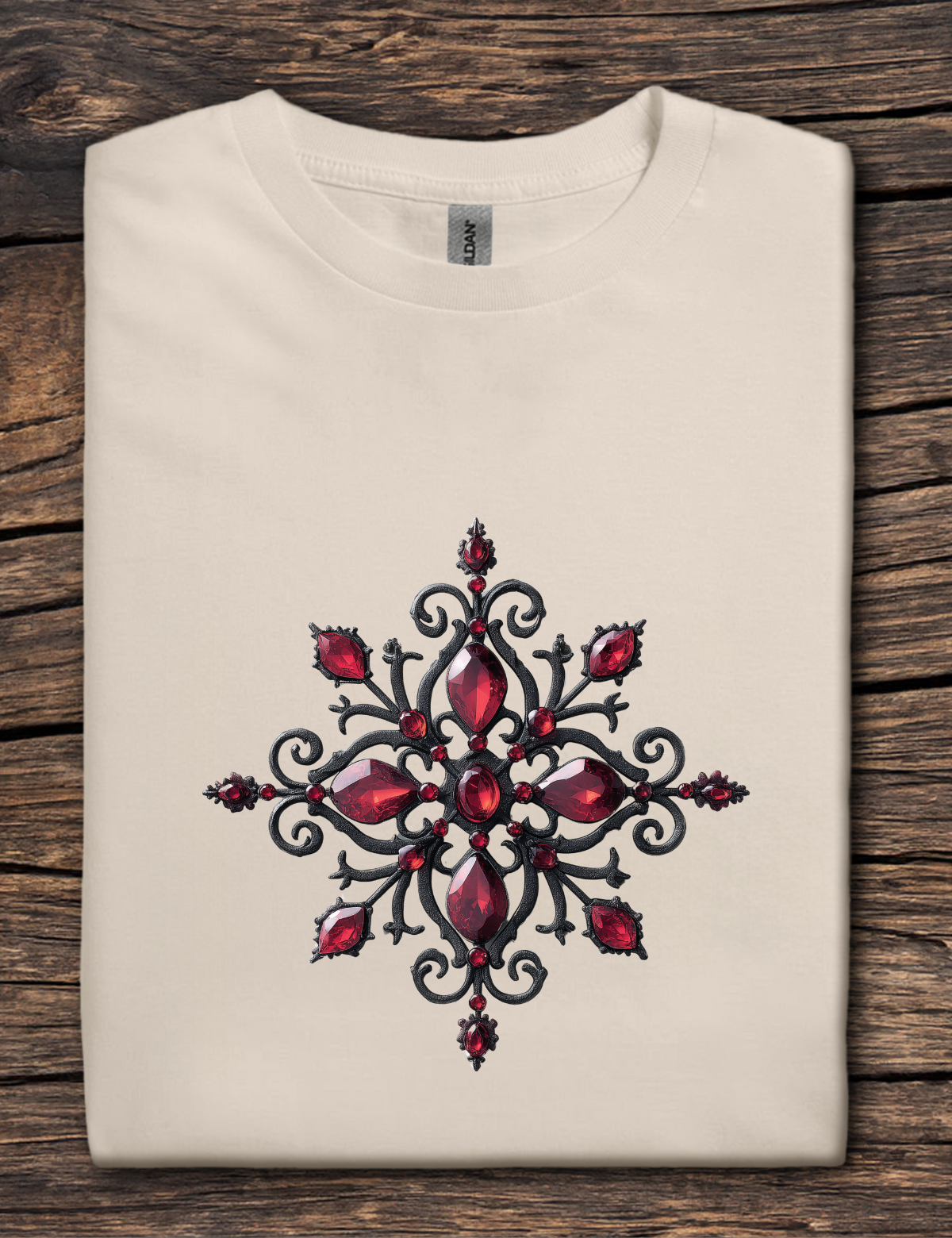 Folded beige t-shirt with a red and black geometric design on a wooden surface