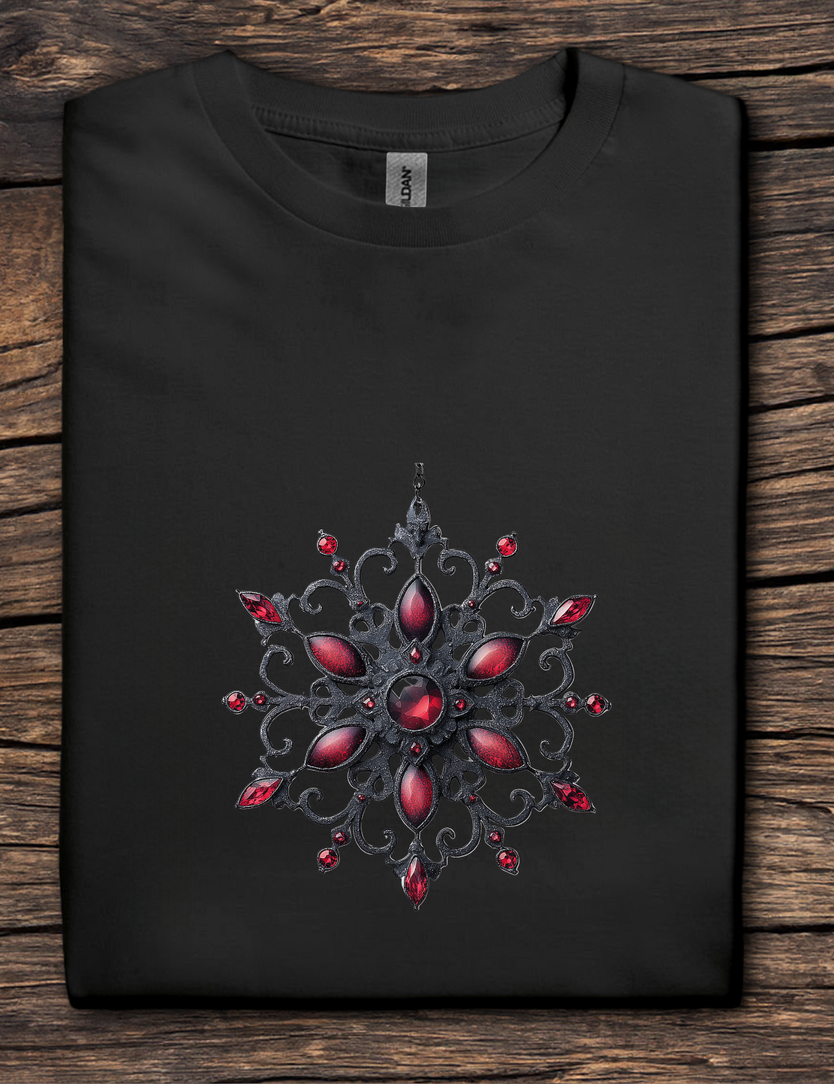 Black t-shirt with a decorative red and black design on a wooden surface