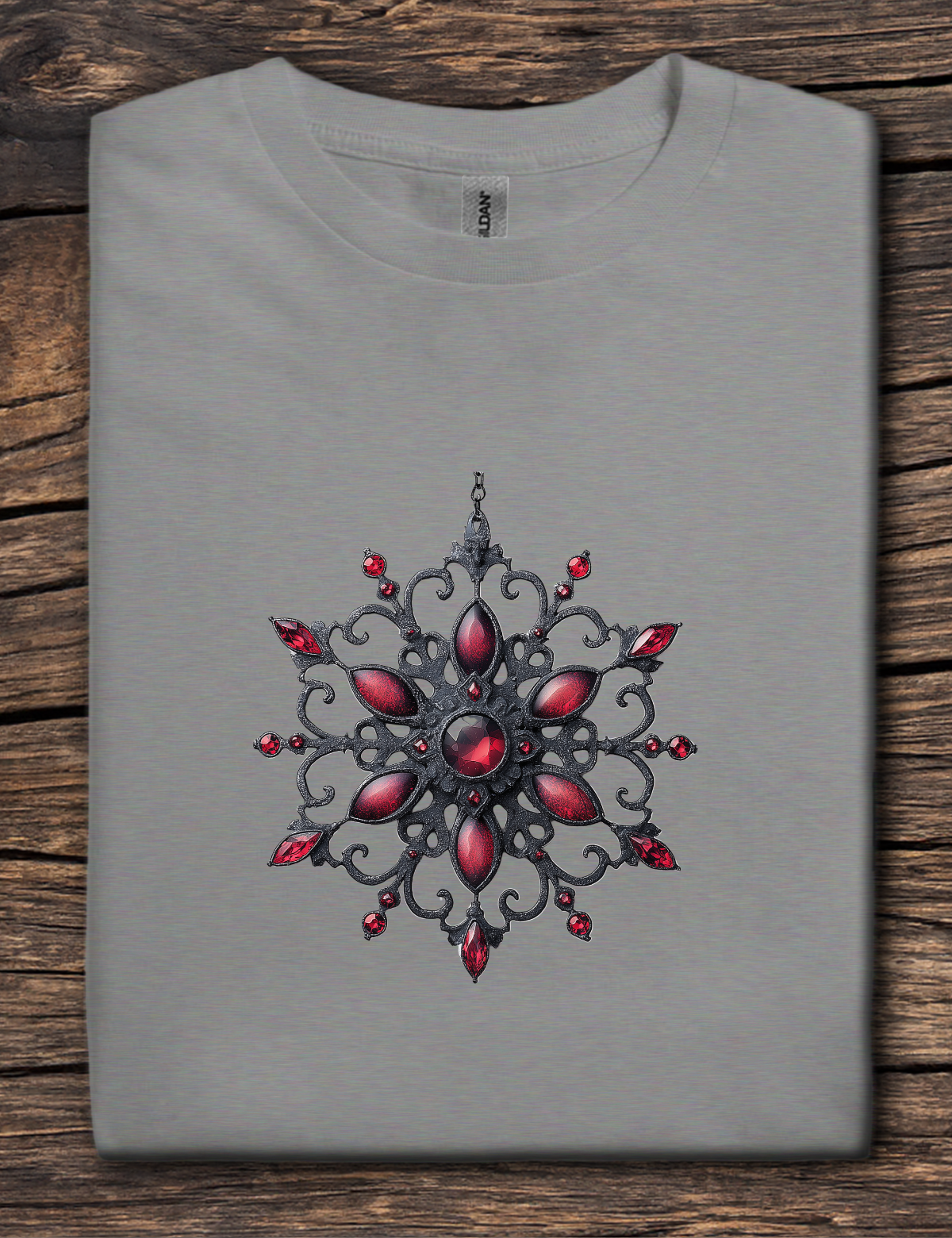 Gray t-shirt with a decorative red and black design on a wooden surface